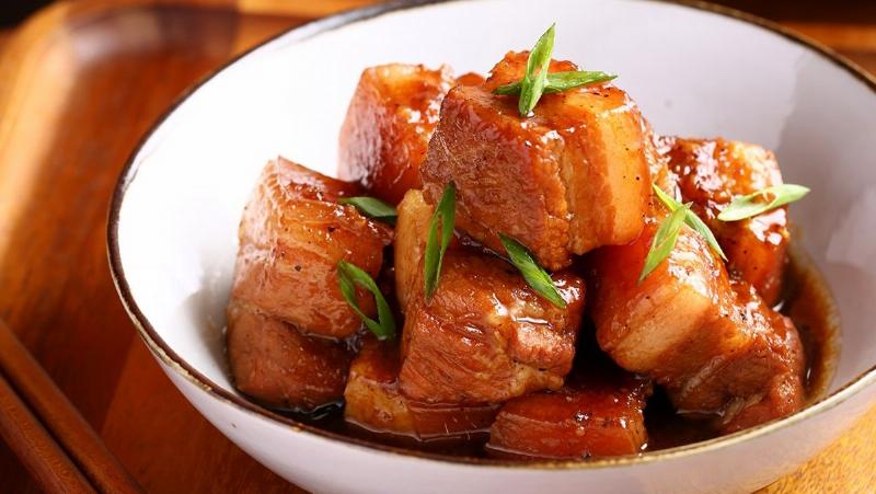 Dĩa thịt kho nghệ kiểu miền Trung (Huế) với thịt chân giò, màu sắc đậm hơn và có thể có thêm ớt hoặc măng